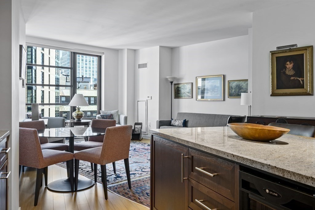 580 Washington Street, Unit 12E Boston, MA 02111 - Photo 4 of 12 a dining room with granite countertop furniture and a granite counter space