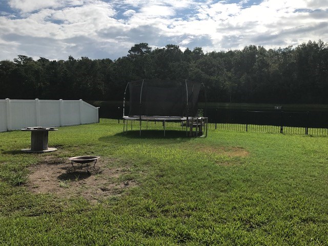 88392 Maybourne Road Yulee, FL 32097 - Photo 32 of 34 a swimming pool with some trees in the background
