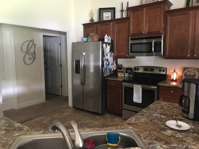88392 Maybourne Road Yulee, FL 32097 - Photo 34 of 34 a kitchen with stainless steel appliances granite countertop a refrigerator a stove a sink and a microwave