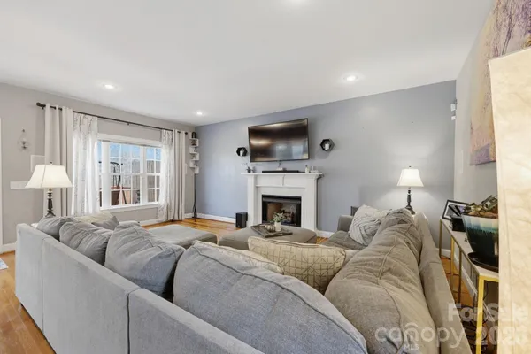 a living room with furniture a fireplace and a flat screen tv