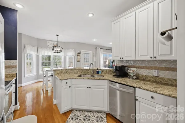 a kitchen with granite countertop a sink a stove and cabinets