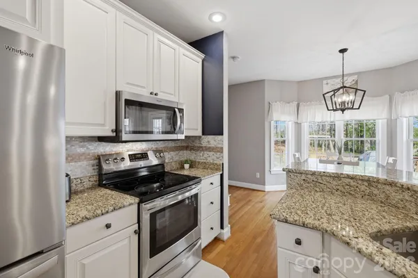 a kitchen with stainless steel appliances granite countertop a stove and a refrigerator