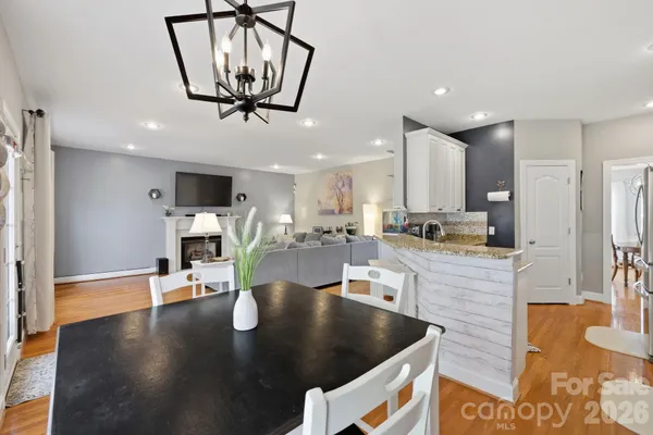 a kitchen with stainless steel appliances granite countertop a sink a table and chairs