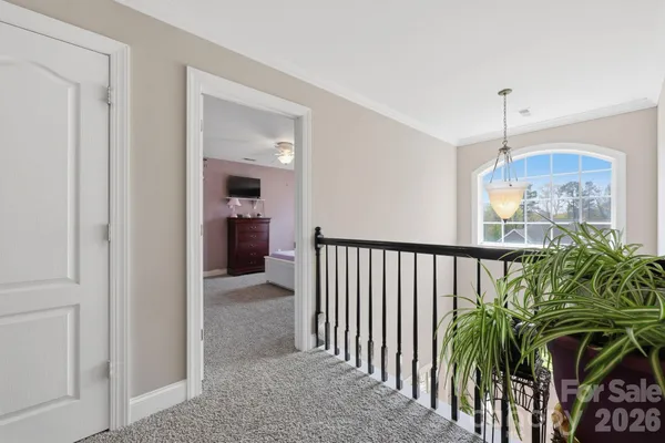 a view of a hallway to a livingroom with furniture and stairs