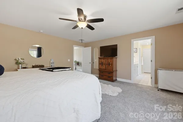 a spacious bedroom with a bed and a chandelier
