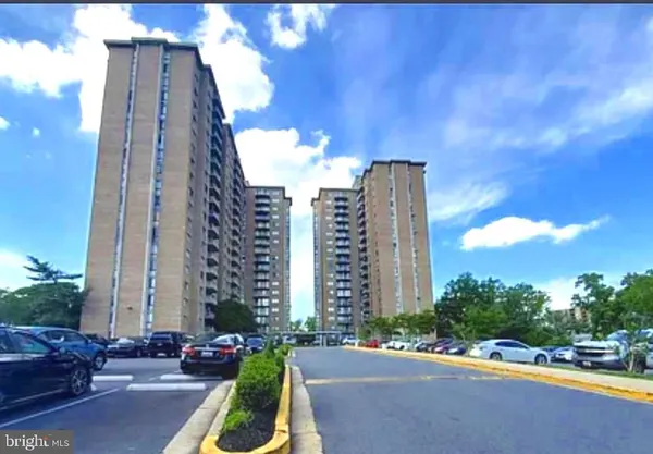 a city street with tall buildings in the background