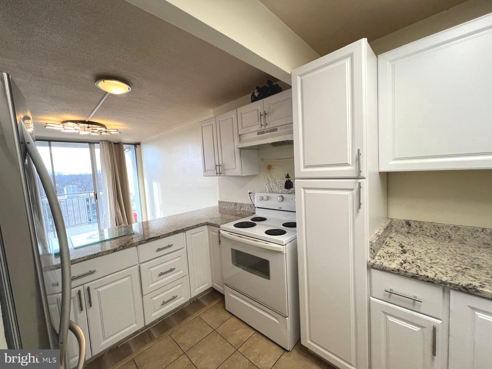 1836 Metzerott Road, Unit 916 Adelphi, MD 20783 - Photo 12 of 42 a kitchen with white cabinets and white appliances