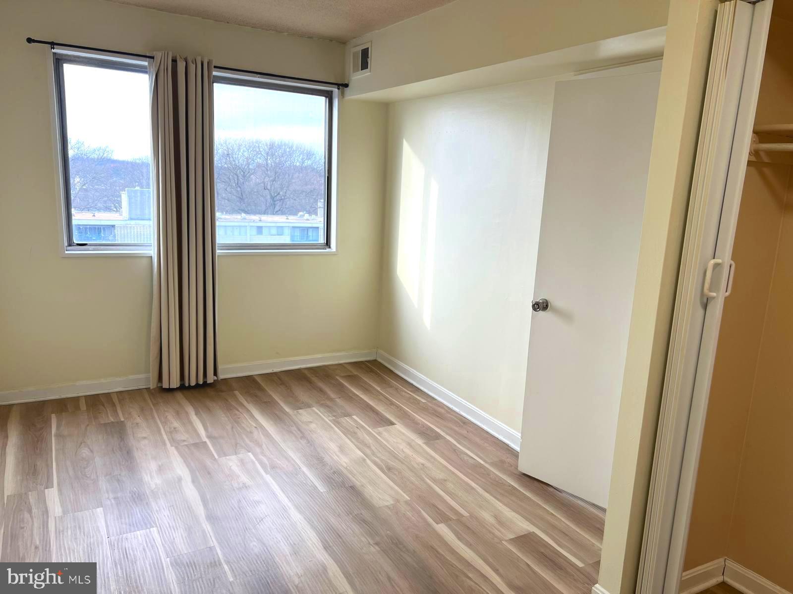 1836 Metzerott Road, Unit 916 Adelphi, MD 20783 - Photo 15 of 42 an empty room with wooden floor and windows