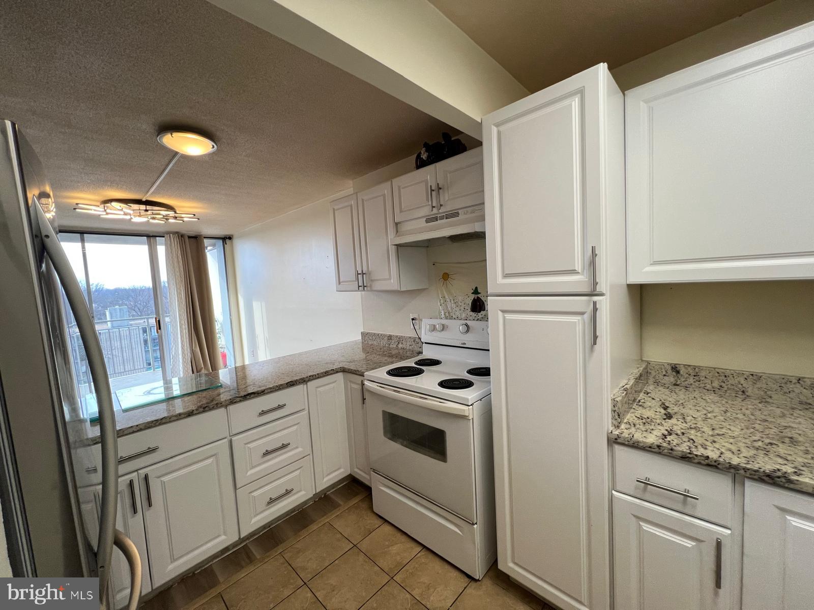 1836 Metzerott Road, Unit 916 Adelphi, MD 20783 - Photo 29 of 29 a kitchen with white cabinets and white appliances