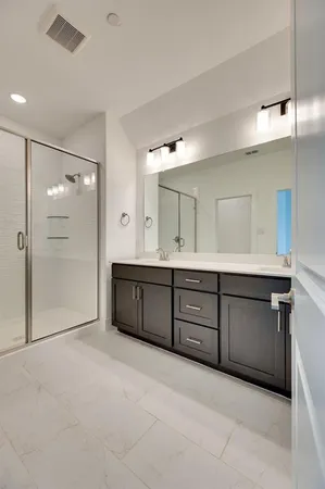a spacious bathroom with a mirror sink and shower