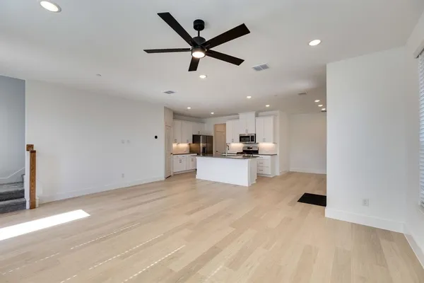 a view of an empty room and kitchen view