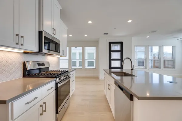 a kitchen with granite countertop a stove sink and cabinets