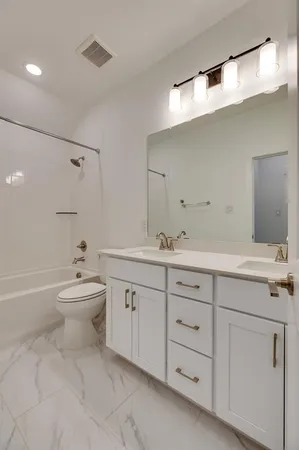 a bathroom with a toilet a sink a mirror and a bathtub