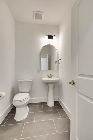 a bathroom with a sink toilet and a mirror