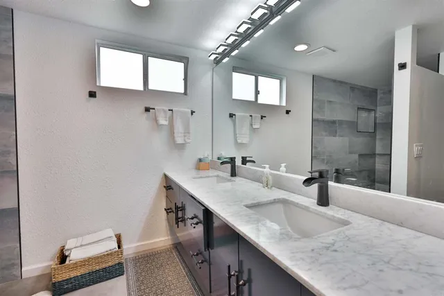 a bathroom with a granite countertop sink a toilet and a mirror