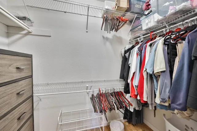 a view of walk in closet with clothes