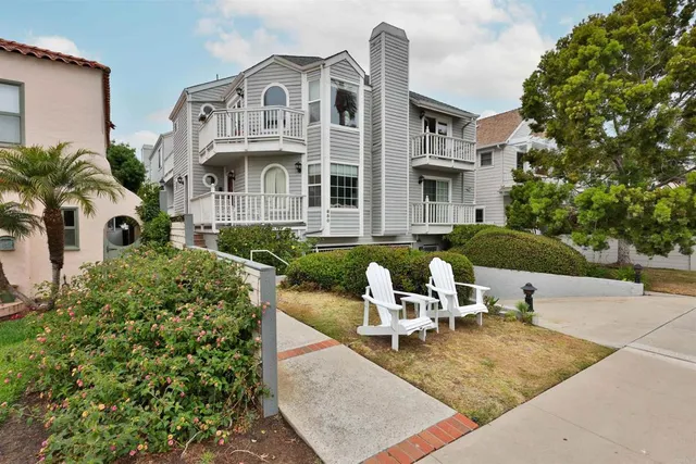a view of a white building with a fountain in front of a house