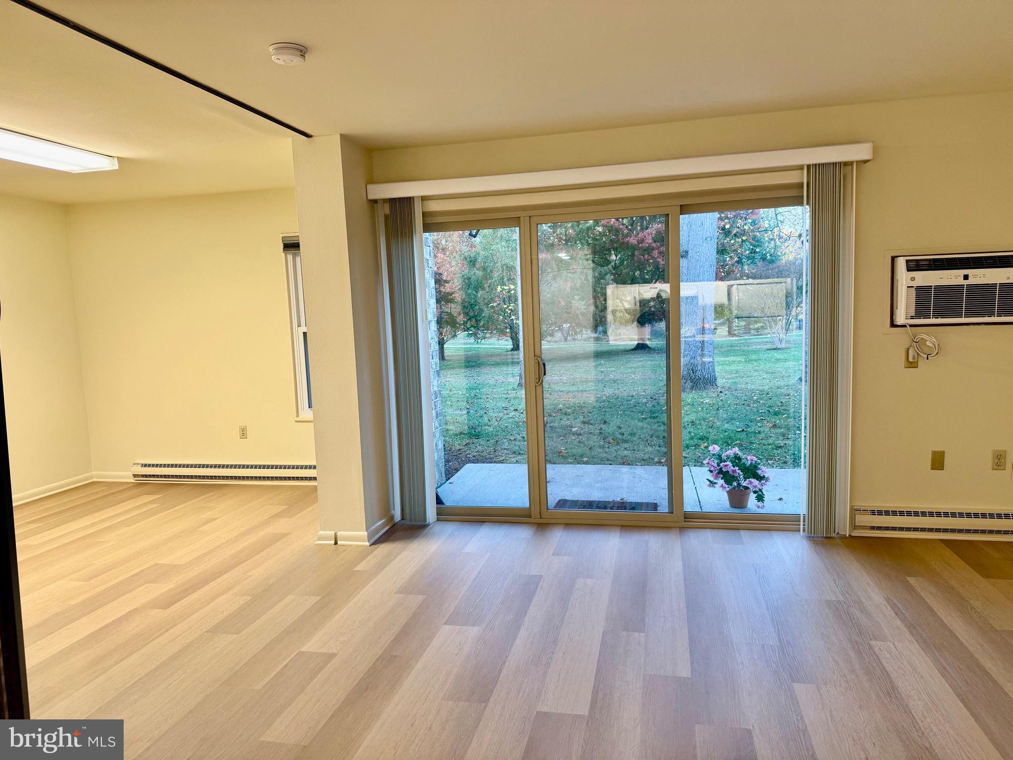 3301 South Leisure World Boulevard, Unit 991H Silver Spring, MD 20906 - Photo 9 of 25 a view of an empty room with wooden floor and a window