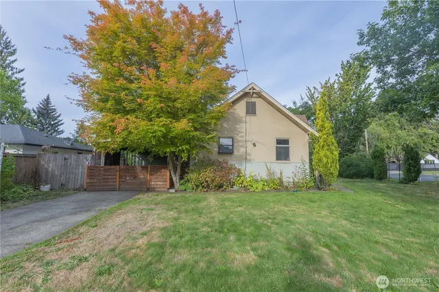 a front view of a house with a yard and trees