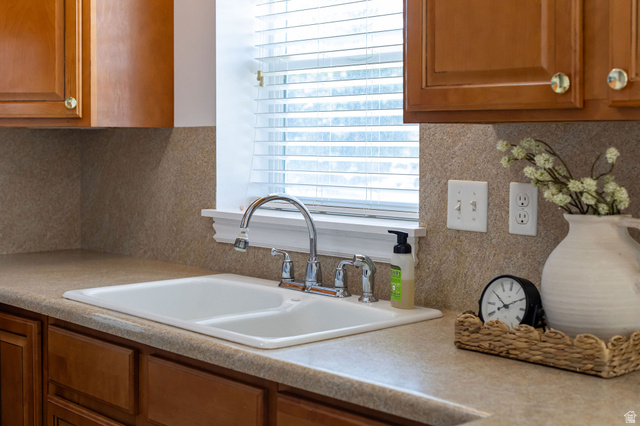 80 North 500 West Logan, UT 84321 - Photo 7 of 36 Wood-finish cabinetry, double basin sink, chrome faucet, window with blinds, and light-colored countertop