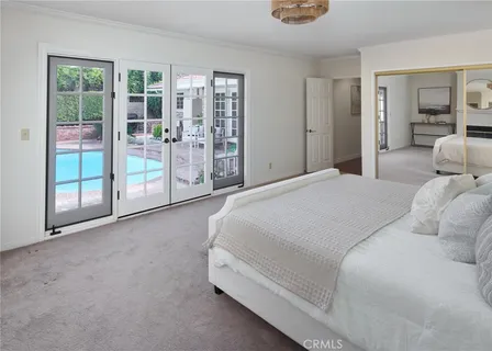 a spacious bedroom with a bed and glass door
