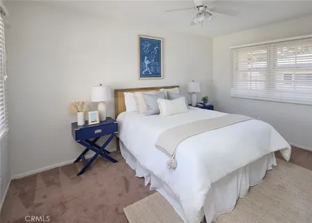 a bedroom with a bed a chandelier and a window