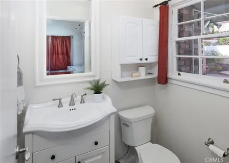 a bathroom with a toilet a sink and mirror