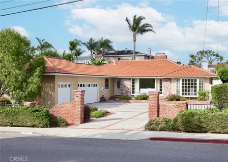 a front view of a house with a yard and potted plants