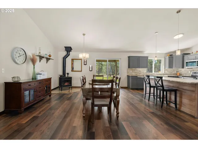 a kitchen with stainless steel appliances granite countertop a table chairs refrigerator and sink