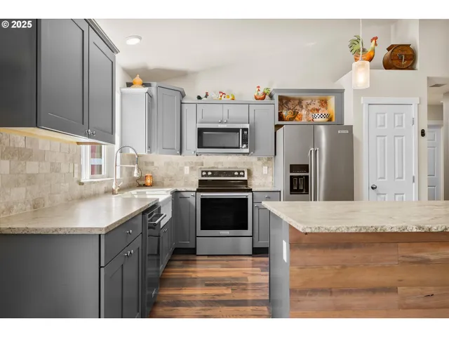 a kitchen with granite countertop a sink stainless steel appliances and cabinets