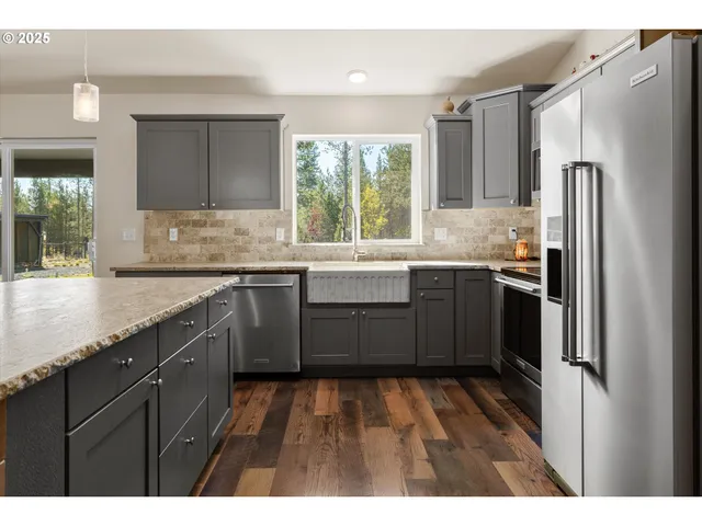 a kitchen with lots of wooden furniture a refrigerator and a dining table