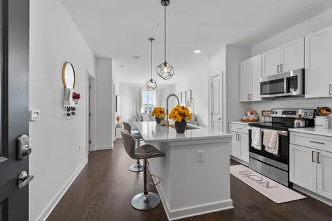 a kitchen with stainless steel appliances granite countertop a sink a stove a refrigerator and cabinets