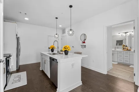a kitchen with a sink and wooden floor