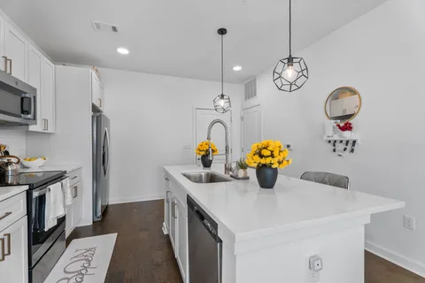 a kitchen with stainless steel appliances a kitchen island a stove and a sink