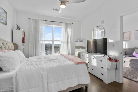 a bedroom with a bed and flat tv screen on the dresser