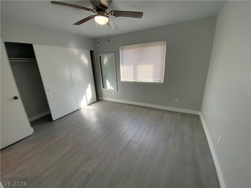 466 East Sunset Road, Unit C Henderson, NV 89011 - Photo 12 of 12 Unfurnished bedroom featuring a ceiling fan, wood finished floors, baseboards, and a closet