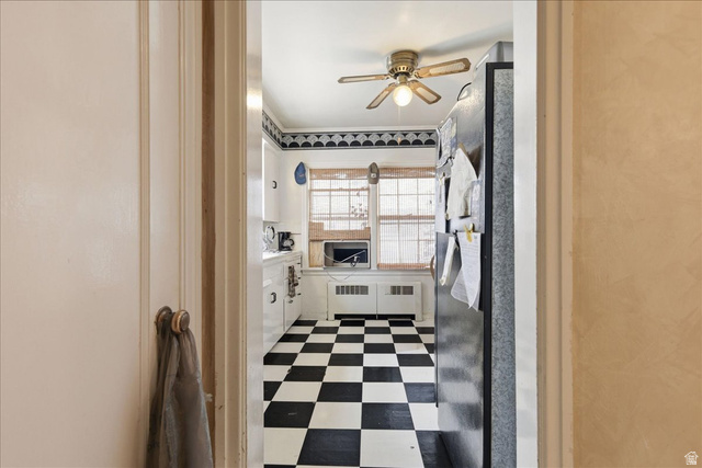348 East 200 North Logan, UT 84321 - Photo 21 of 41 Kitchen featuring black and white checkerboard flooring, white cabinetry, a double window, and a ceiling fan with light fixture