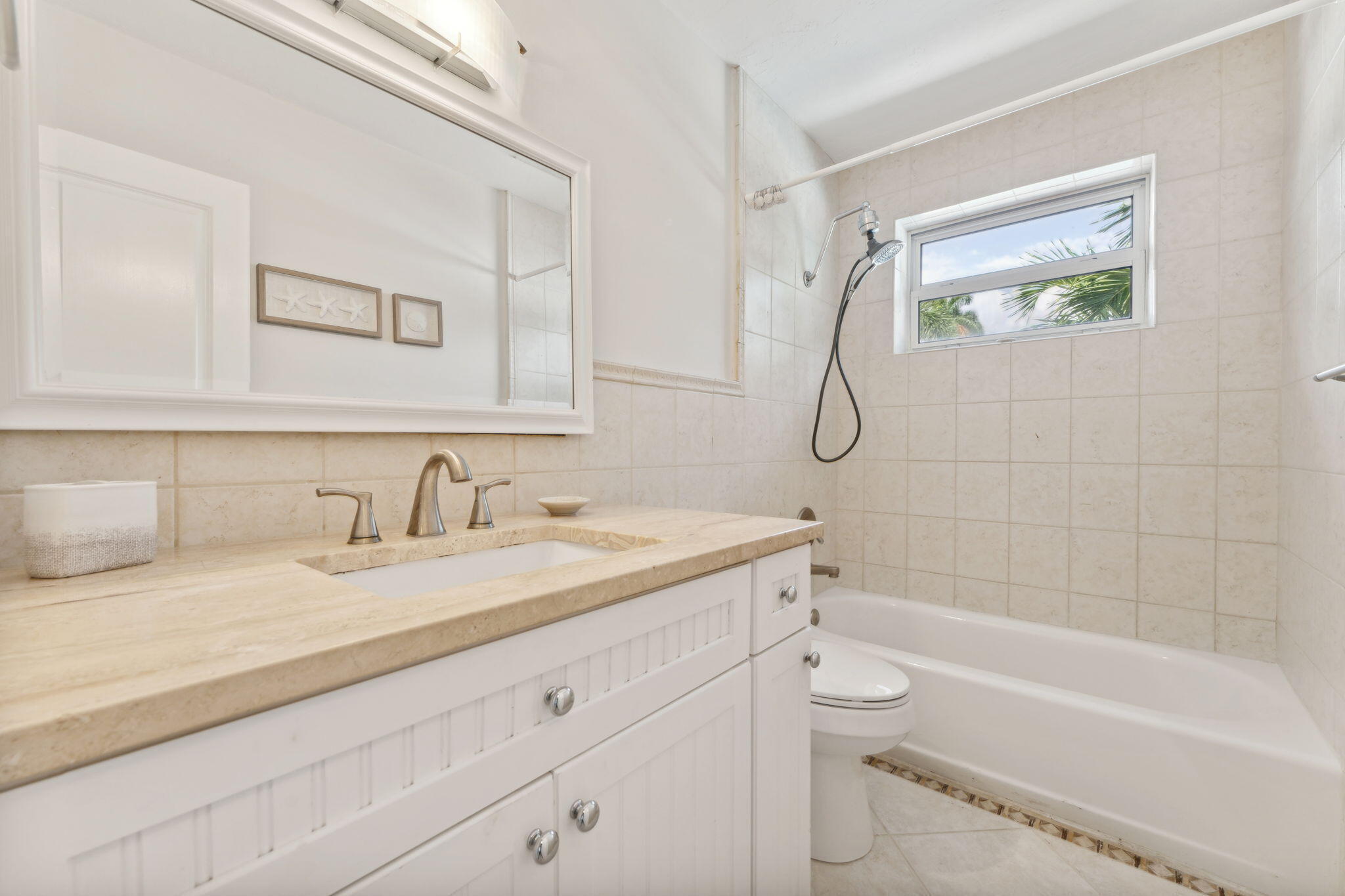 2691 Northeast 18th Street Pompano Beach, FL 33062 - Photo 19 of 34 a bathroom with a granite countertop sink a toilet and a bathtub