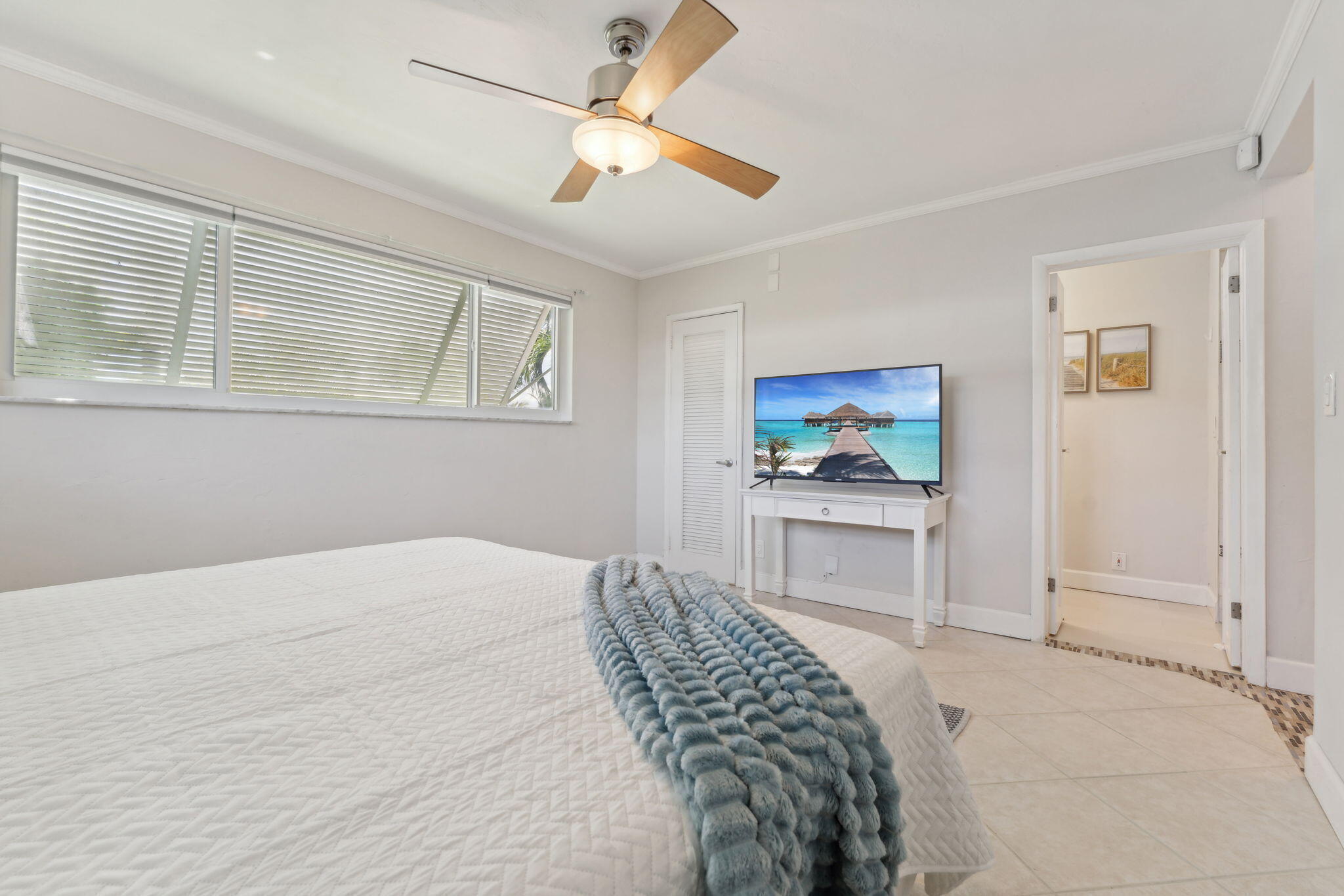 2691 Northeast 18th Street Pompano Beach, FL 33062 - Photo 22 of 34 a bedroom with a bed and a chandelier