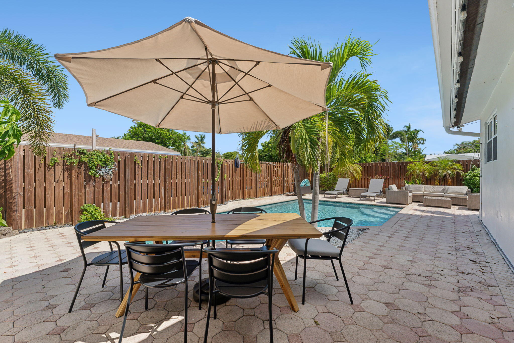 2691 Northeast 18th Street Pompano Beach, FL 33062 - Photo 24 of 34 a patio with a table and chairs under an umbrella