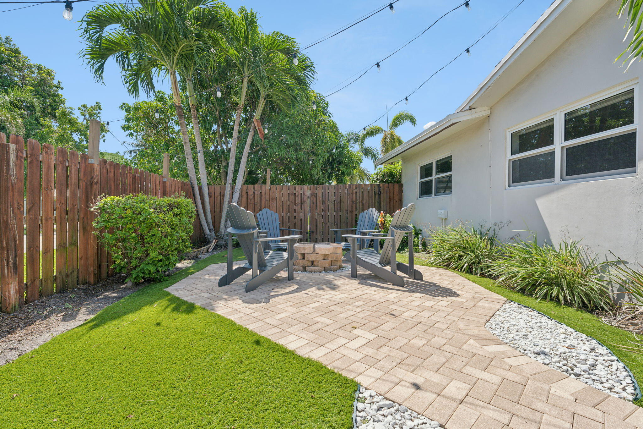 2691 Northeast 18th Street Pompano Beach, FL 33062 - Photo 28 of 34 a view of a backyard with table and chairs potted plants and wooden fence