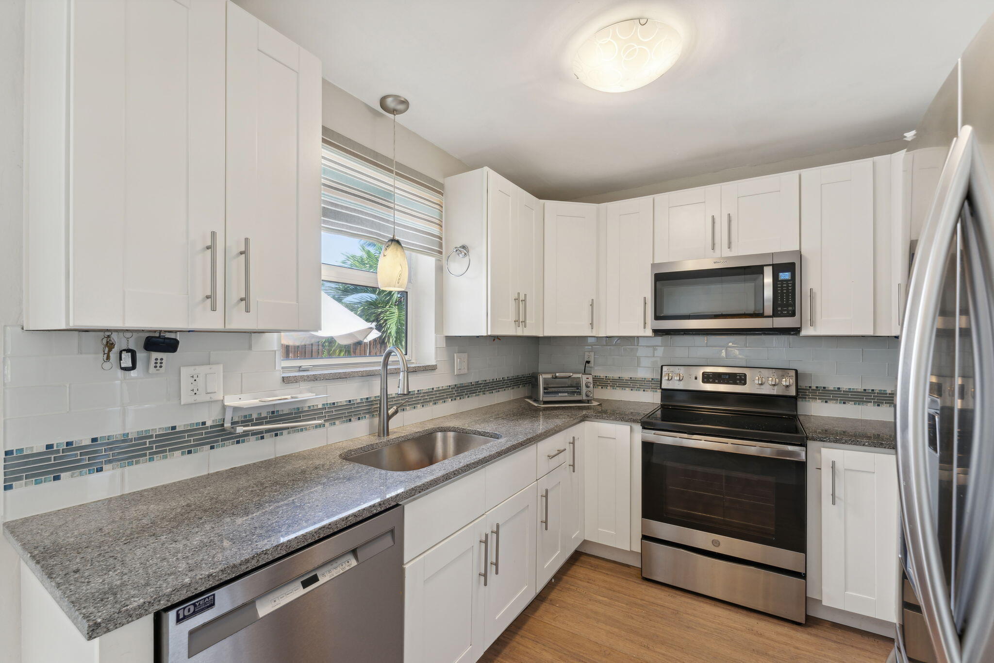2691 Northeast 18th Street Pompano Beach, FL 33062 - Photo 10 of 34 a kitchen with white cabinets appliances and a sink