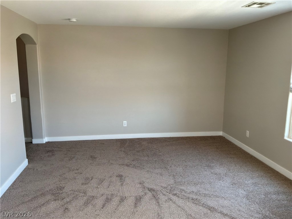 9041 Rendon Street Las Vegas, NV 89143 - Photo 12 of 34 Plush wall-to-wall carpeting and neutral walls define this versatile room framed by arched transitions.