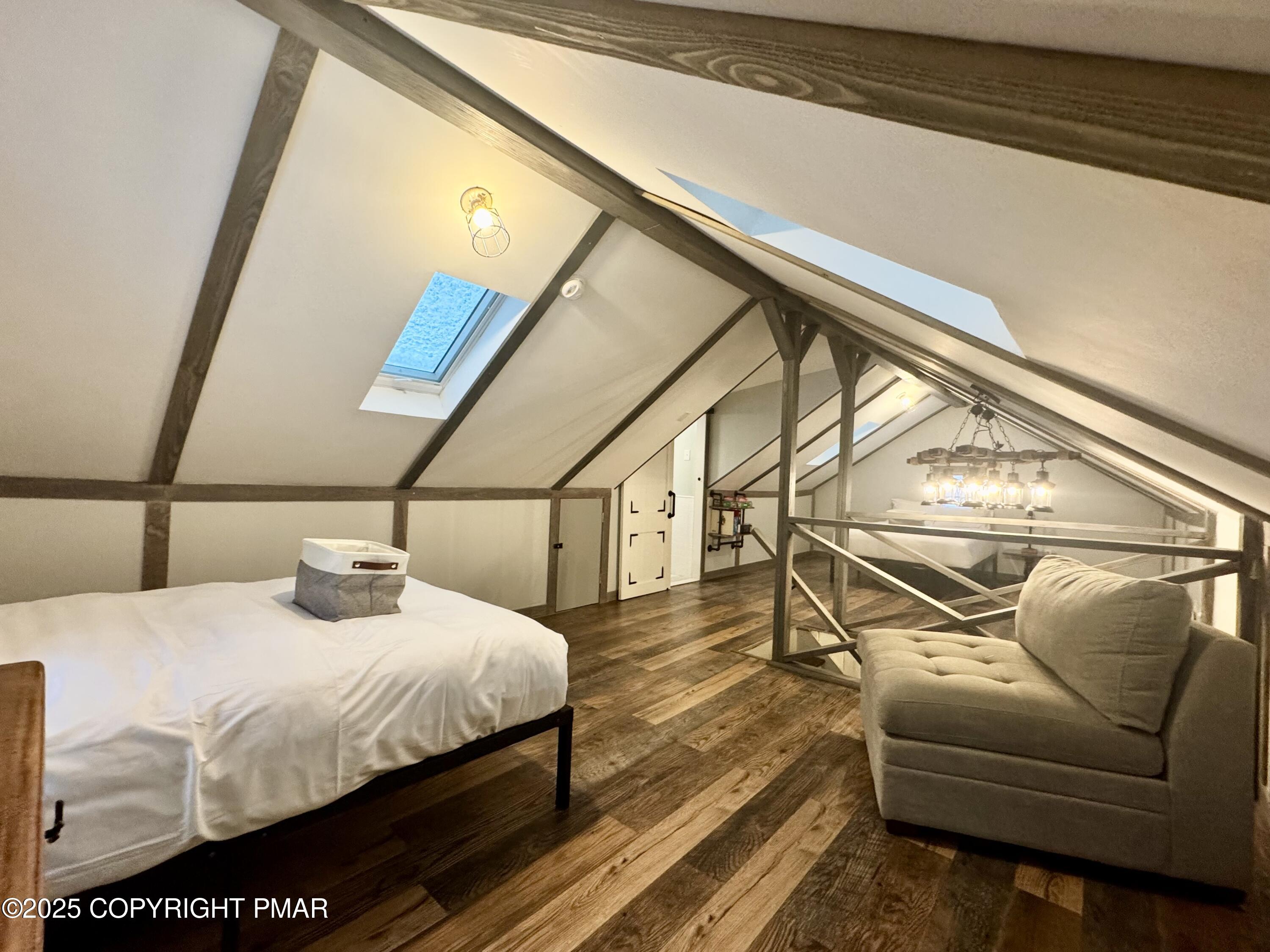 24 Split Rock Road Lake Harmony, PA 18624 - Photo 17 of 42 a bedroom with a bed a couch and wooden floor