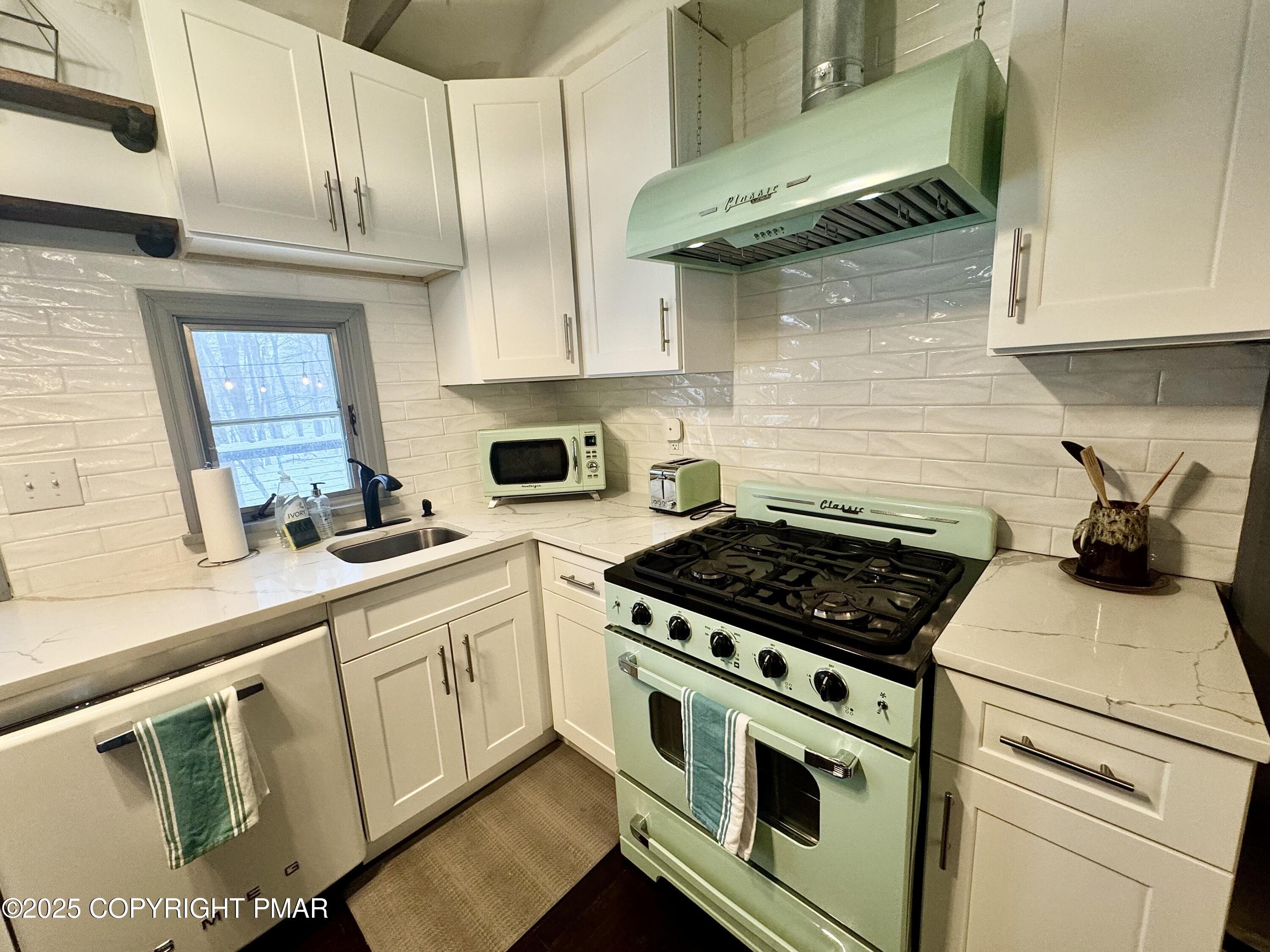 24 Split Rock Road Lake Harmony, PA 18624 - Photo 9 of 42 a kitchen with stainless steel appliances white cabinets and a stove top oven
