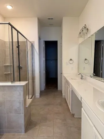 a large bathroom with a double vanity sink and mirror