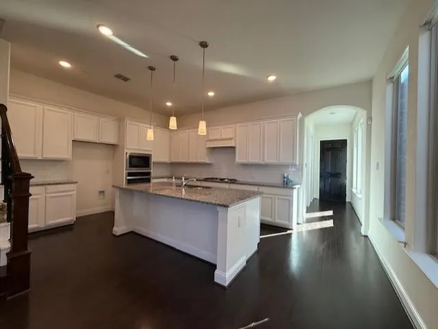 a kitchen with stainless steel appliances granite countertop a stove a sink and a refrigerator