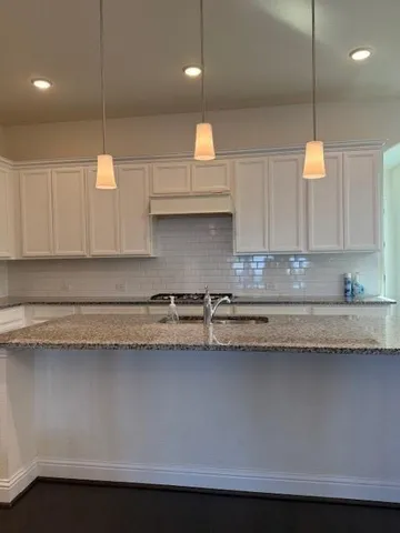 a kitchen with a sink a counter top space cabinets and stainless steel appliances