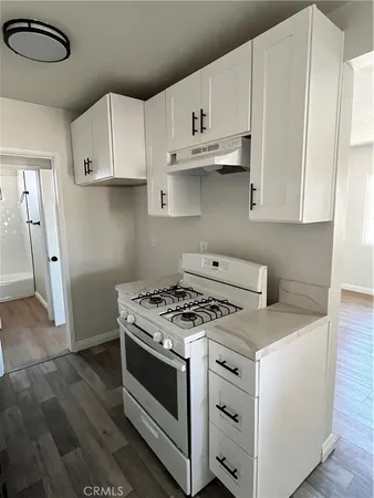a kitchen with white cabinets and white appliances