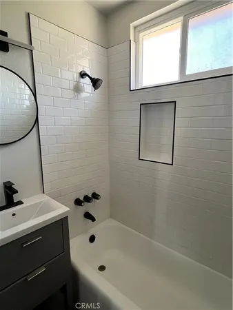 a bathroom with a bathtub sink and mirror